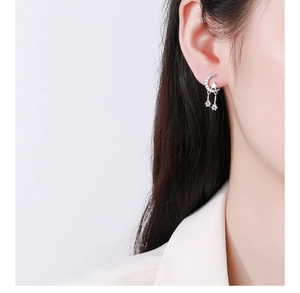 Detail of 925 sterling silver star and moon tassel earrings worn by a model