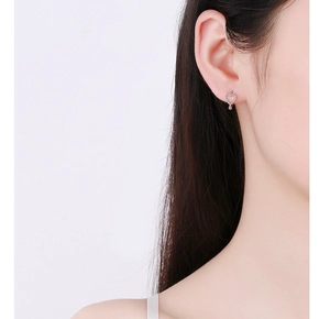Close-up of minimalist 925 sterling silver hollow heart earrings worn on earlobe