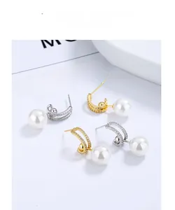 Détail de boucles d'oreilles perles en argent 925 avec zircons sur fini argent et or 18k