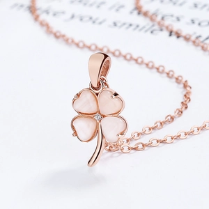 Rose gold clover necklace with heart-shaped cat's eye stones and central crystal pendant