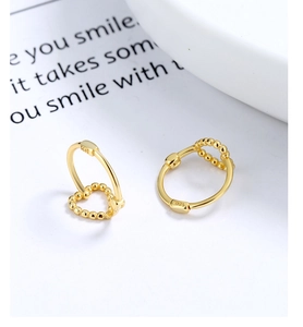 Detailed view of S925 sterling silver stamp on 18K gold-plated heart-shaped hoop earrings