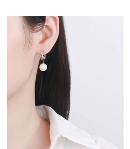 Gros plan de boucles d'oreilles perles avec pavé de cristaux sur un mannequin