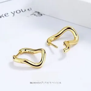 Macro shot of 925 sterling silver twisted wave earrings with high-shine gold plating