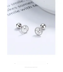 Macro shot of 925 sterling silver asymmetric studs with letter H and sparkling star