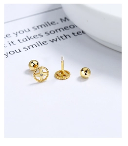 Macro detail of gold four-pointed star earrings with screw back and cubic zirconia center