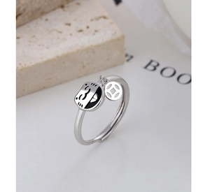 Macro view of 925 silver lucky cat ring featuring a small dangling copper coin charm