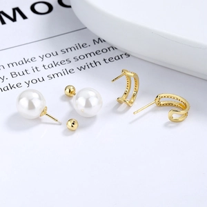 Boucles d'oreilles perles et créoles dorées pavées style français sur un magazine