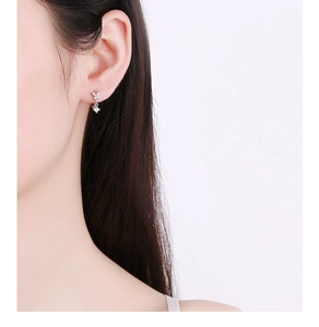 Close-up of 925 sterling silver bow earrings with tassels and sparkling zircon stones