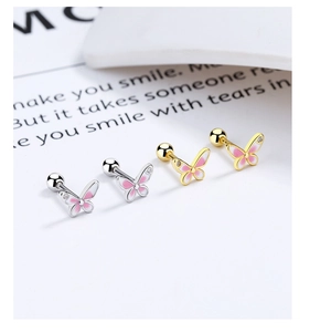 Detail of pink butterfly screw-back earrings in gold and silver finish with zircon
