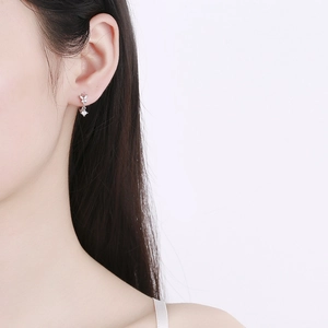 Elegant 925 sterling silver bow earrings with zircon tassel pendant on a model