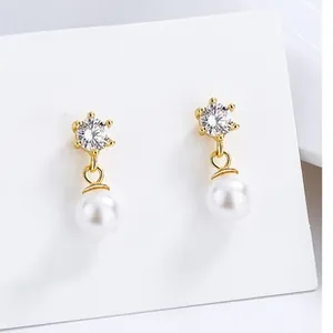Detailed view of 925 silver six-prong cubic zirconia and pearl drop earrings