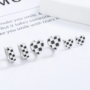 Vue détaillée des boucles d'oreilles en argent 925 avec cœur noir et damier émaillé