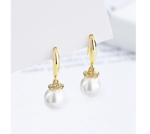 Gros plan de boucles d'oreilles perles dorées avec détails en zircon sur fond blanc