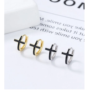 Détail de boucles d'oreilles huggie argent et or avec breloque croix en émail noir