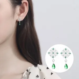 Detailed close-up of 925 sterling silver emerald green pear-cut drop earrings on model