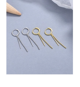 Detail of elegant gold and silver tassel drop earrings with sleek bead chains