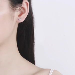 S925 silver pink butterfly stud earrings worn on ear for a minimalist jewelry style