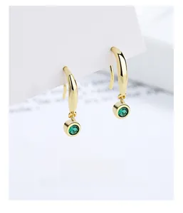 Detailed view of 925 silver gold-plated hook earrings with emerald green gemstones