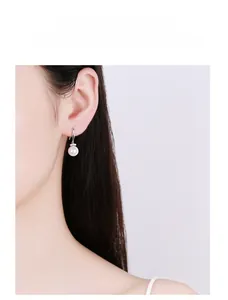 Détails de longues boucles d'oreilles en perles argent 925 avec zircons sur un mannequin