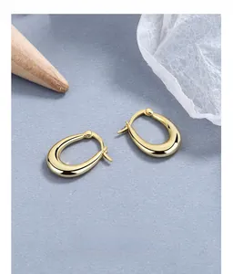 Macro shot of polished teardrop gold earrings with S925 sterling silver hallmark