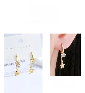 Detail of S925 sterling silver star drop earrings with gold finish and zircon stones