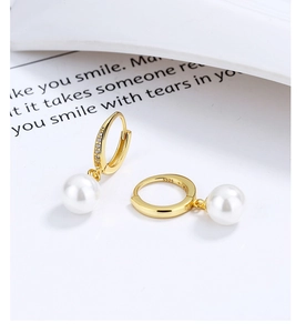 Close-up of S925 sterling silver hallmark on gold pearl drop earrings with zircon