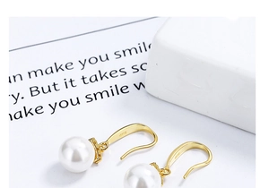 Détail du poinçon S925 sur les boucles d'oreilles longues en perles et argent