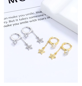 Detailed close-up of star tassel earrings in gold and silver finishes with zircon