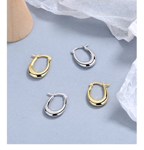Detail of gold and silver U-shaped 925 sterling silver earrings with S925 hallmark