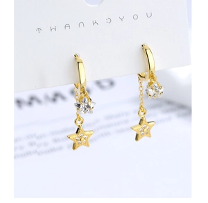 Macro detail of gold star drop earrings with crystal charms on a display card