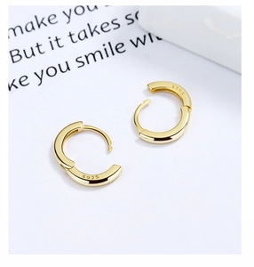 Detailed close-up of 925 sterling silver S925 hallmark on minimalist gold hoop earrings
