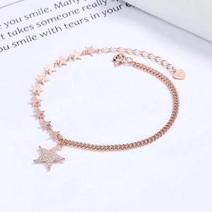 Detail of rose gold 925 silver bracelet featuring star charms and sparkling crystals
