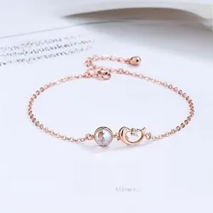 Macro detail of rose gold bracelet with crystal dolphin and opal-like gemstone