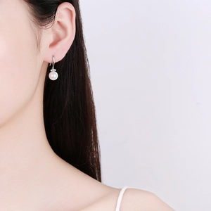 Élégantes boucles d'oreilles pendantes en argent sterling et perle sur mannequin