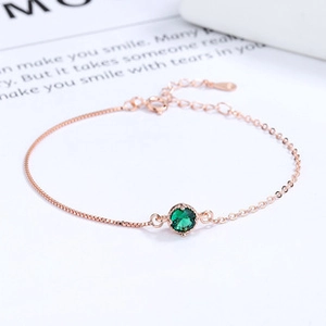 Close-up of rose gold butterfly bracelet with green crystal and S925 hallmark