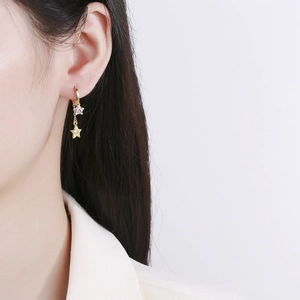 Elegant gold star tassel drop earrings with sparkling pavé cubic zirconia on model