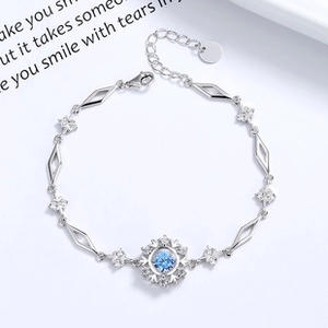 Close-up of a 925 sterling silver snowflake bracelet with a blue center stone and tiny diamonds