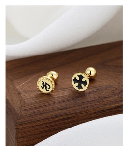 Close-up of gold 925 silver screw back studs with black gothic cross design