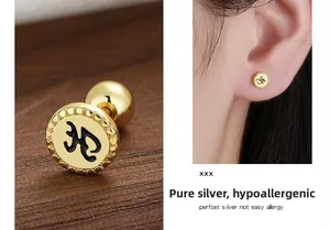 Close-up of gold S925 sterling silver stud earring with black enamel letter H design