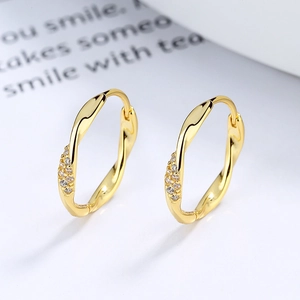 Boucles d'oreilles créoles Mobius dorées au design torsadé avec zircons fins