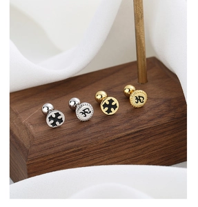 Detail of 925 silver screw back cross earrings displayed on walnut wood with white silk