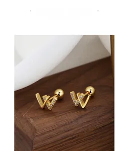 Detailed macro view of letter W screw back stud earrings with pavé crystal accents