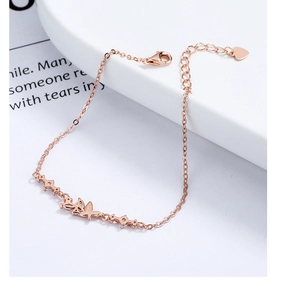Close-up of rose gold butterfly bracelet with white zircon and small heart pendant