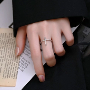Close-up of a 925 sterling silver cross ring with pavé zircons on a hand