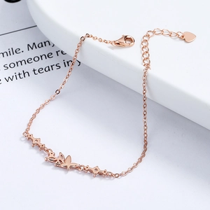 Rose gold butterfly bracelet with zirconia butterfly charms on an elegant white display
