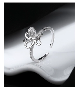 Macro shot of 925 silver bow ring with micro-set zircons on white artistic background