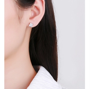 Close-up of minimalist square zircon screw-back stud earring worn on a model's ear