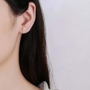 Minimalist gold round earrings for women with artistic engraved letters on the earlobe