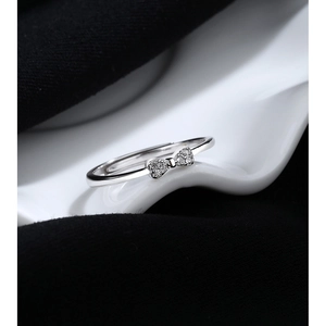 Macro detail of 925 sterling silver bow ring with sparkling zircons on white surface