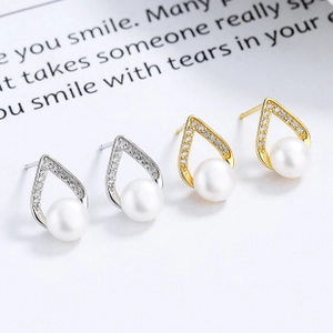 Détail de boucles d'oreilles en argent S925 et or avec perles et zircons pavés